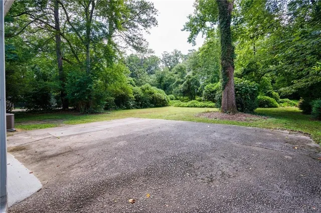 a view of a house with a yard and large tree