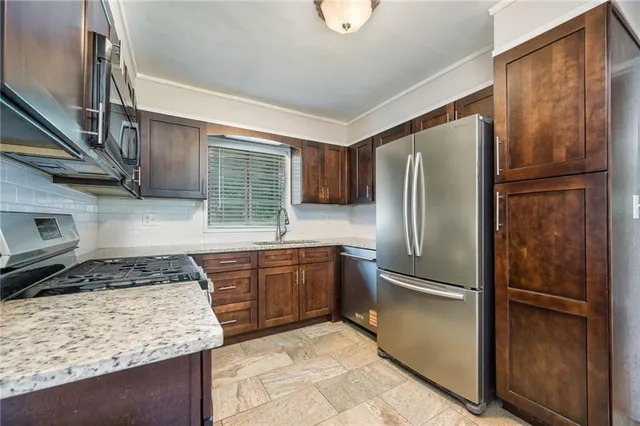 a kitchen with stainless steel appliances granite countertop a refrigerator and a stove