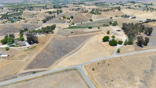 an aerial view of a house with a yard and ocean view