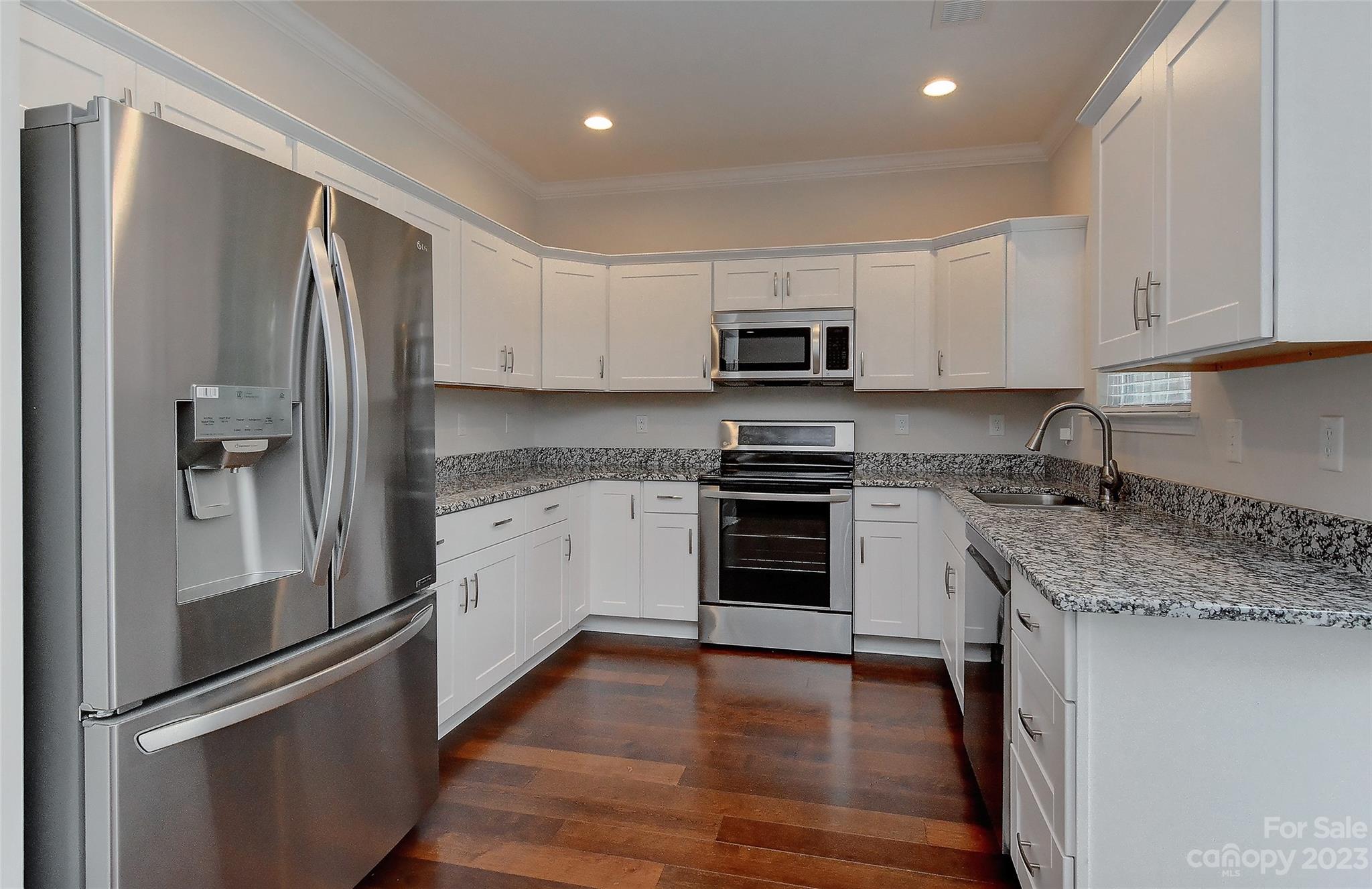 6413 McBride Street Charlotte, NC 28215 - Photo 7 of 21 a kitchen with kitchen island granite countertop stainless steel appliances and wooden cabinets