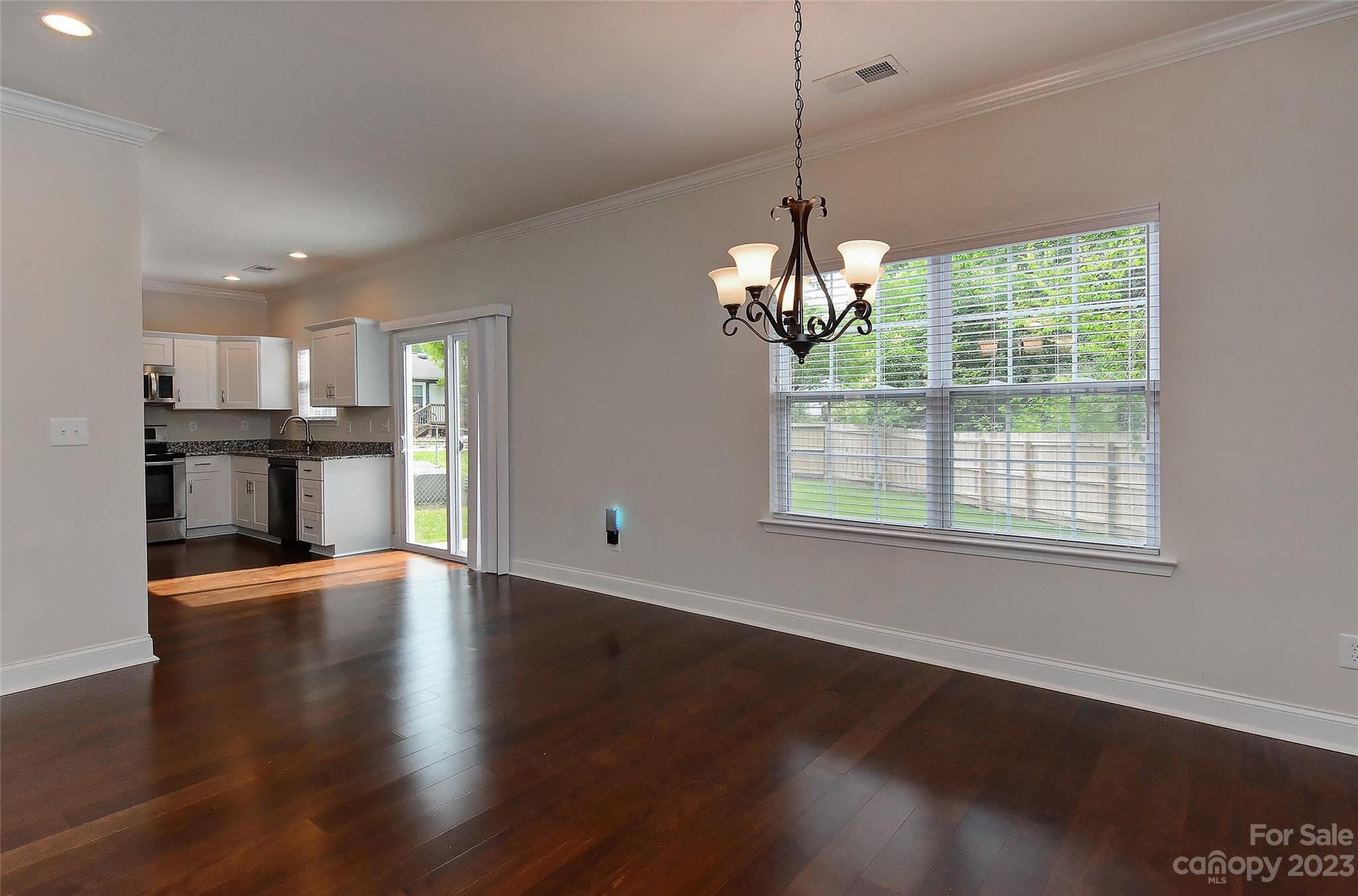 6413 McBride Street Charlotte, NC 28215 - Photo 8 of 21 a view of a room with wooden floors and chandelier