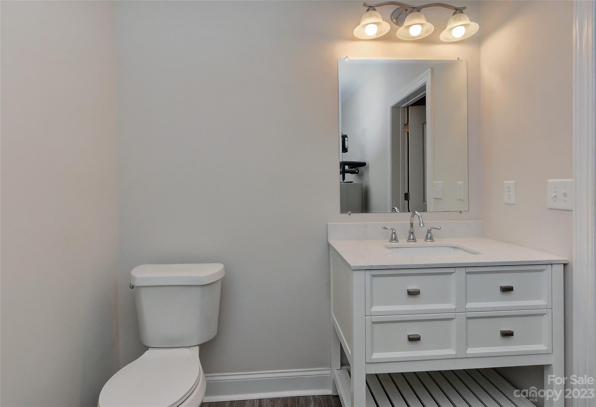 6413 McBride Street Charlotte, NC 28215 - Photo 10 of 21 a bathroom with a toilet a sink a vanity and mirror