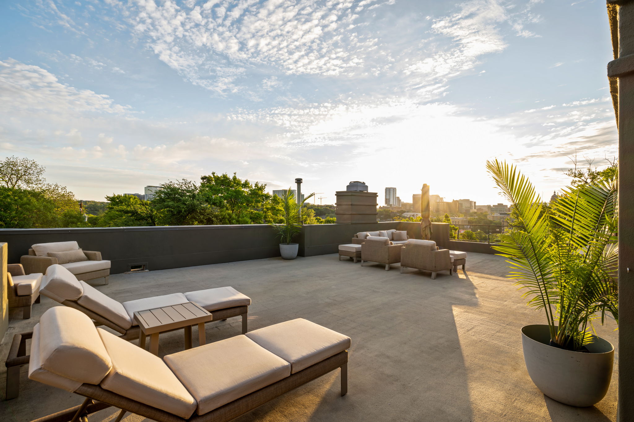 1111 West 12th Street, Unit 107 Austin, TX 78703 - Photo 32 of 38 Expansive rooftop deck featuring a concrete surface, low perimeter wall, and a backdrop of distant city buildings