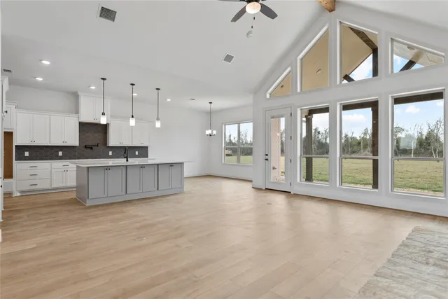 a view of kitchen with kitchen island white cabinets and stainless steel appliances