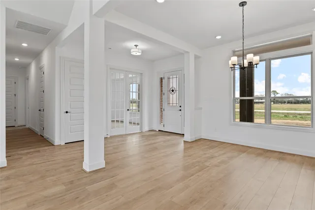 a view of a room with wooden floor ceiling fan and windows