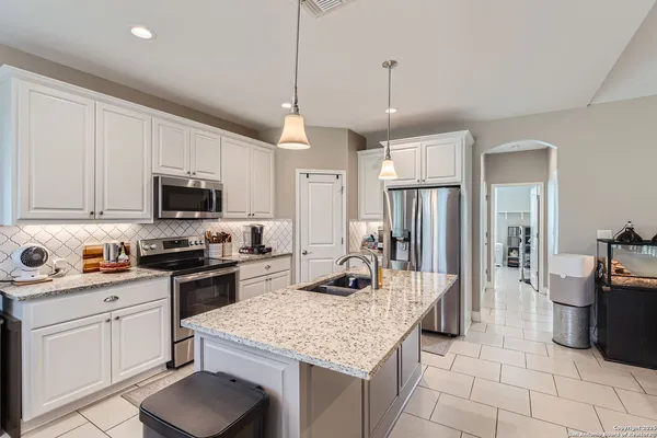 a kitchen with stainless steel appliances granite countertop a stove oven a sink dishwasher and a refrigerator with cabinets
