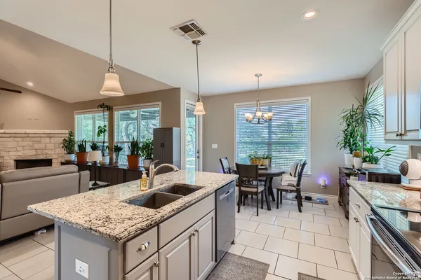 a kitchen with a counter top space a sink stove and cabinets