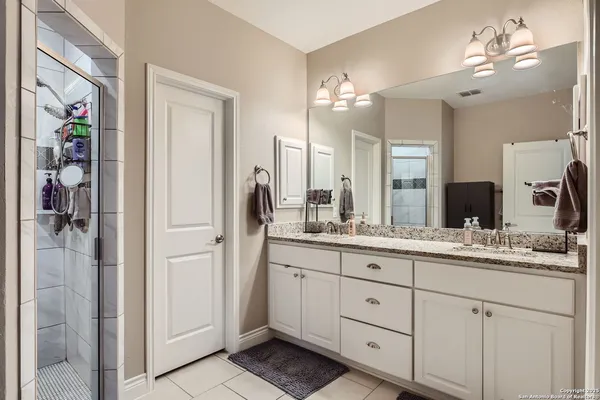 a bathroom with a double vanity sink and a mirror