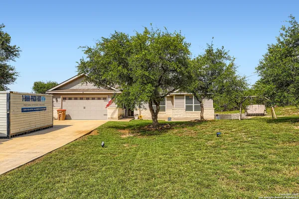 a front view of a house with a yard and trees