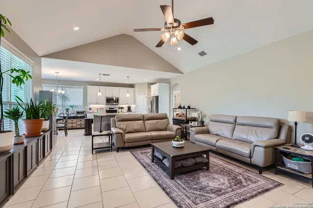 a living room with furniture a chandelier and a rug