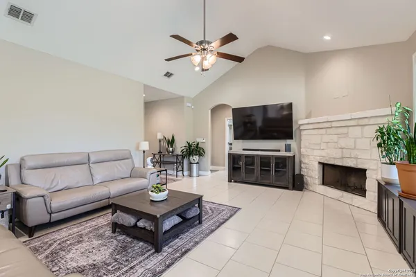 a living room with furniture a flat screen tv and a fireplace