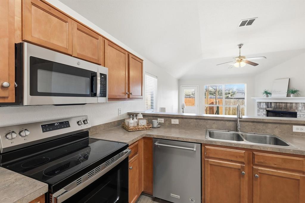 121 Kings Way Drive Rhome, TX 76078 - Photo 11 of 38 a kitchen with stainless steel appliances a sink stove and microwave