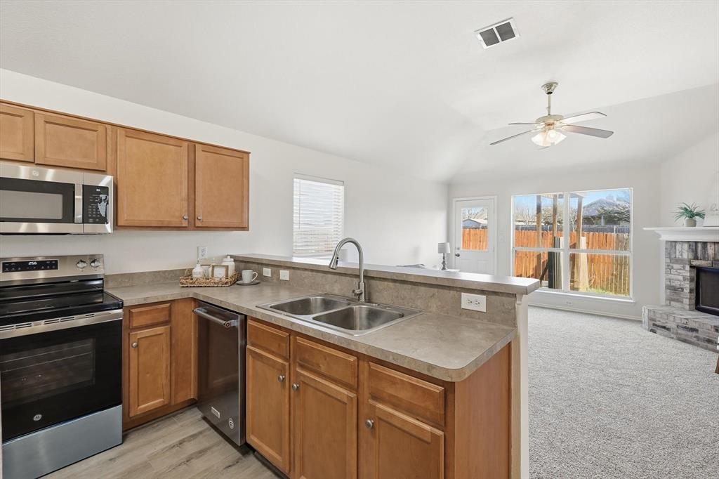 121 Kings Way Drive Rhome, TX 76078 - Photo 12 of 38 a kitchen with stainless steel appliances granite countertop a sink stove and microwave