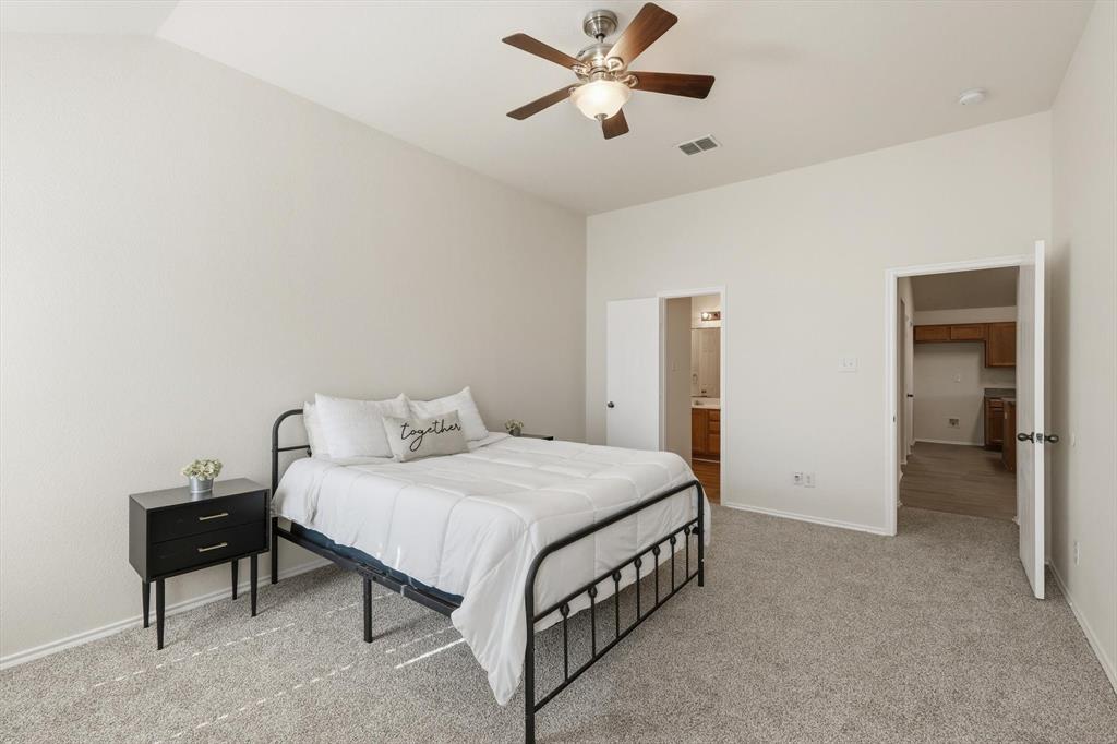 121 Kings Way Drive Rhome, TX 76078 - Photo 22 of 38 a bedroom with a bed and a chandelier