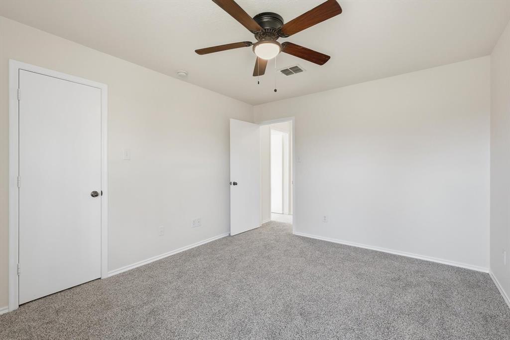 121 Kings Way Drive Rhome, TX 76078 - Photo 33 of 38 an empty room with a ceiling fan and carpet