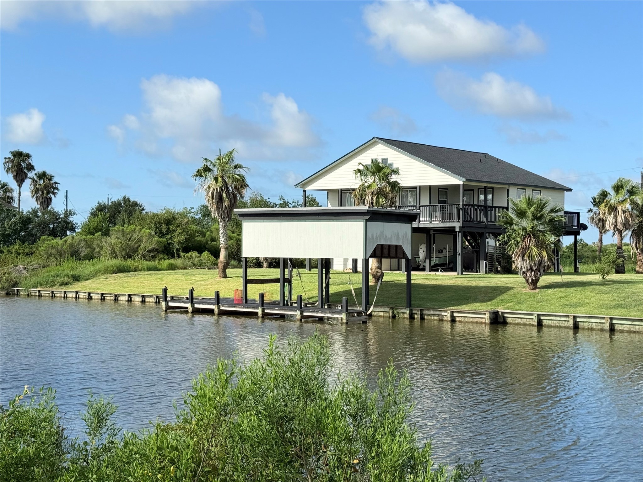 163 County Road 299 Sargent, TX 77414 - Photo 1 of 38 a view of a lake with a table and chairs under an umbrella