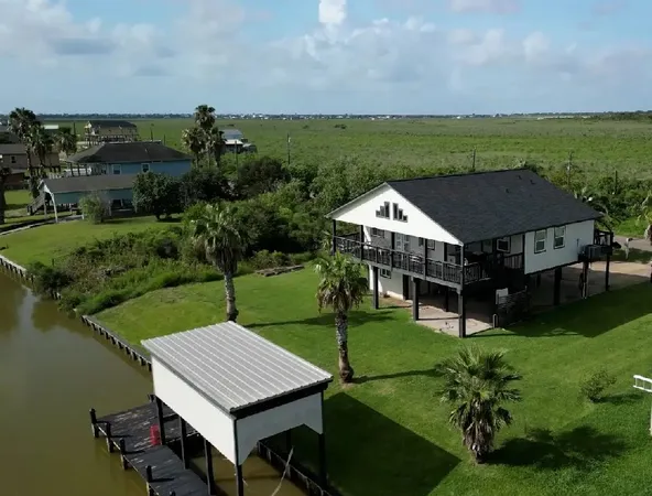 an aerial view of a house with swimming pool garden and lake view