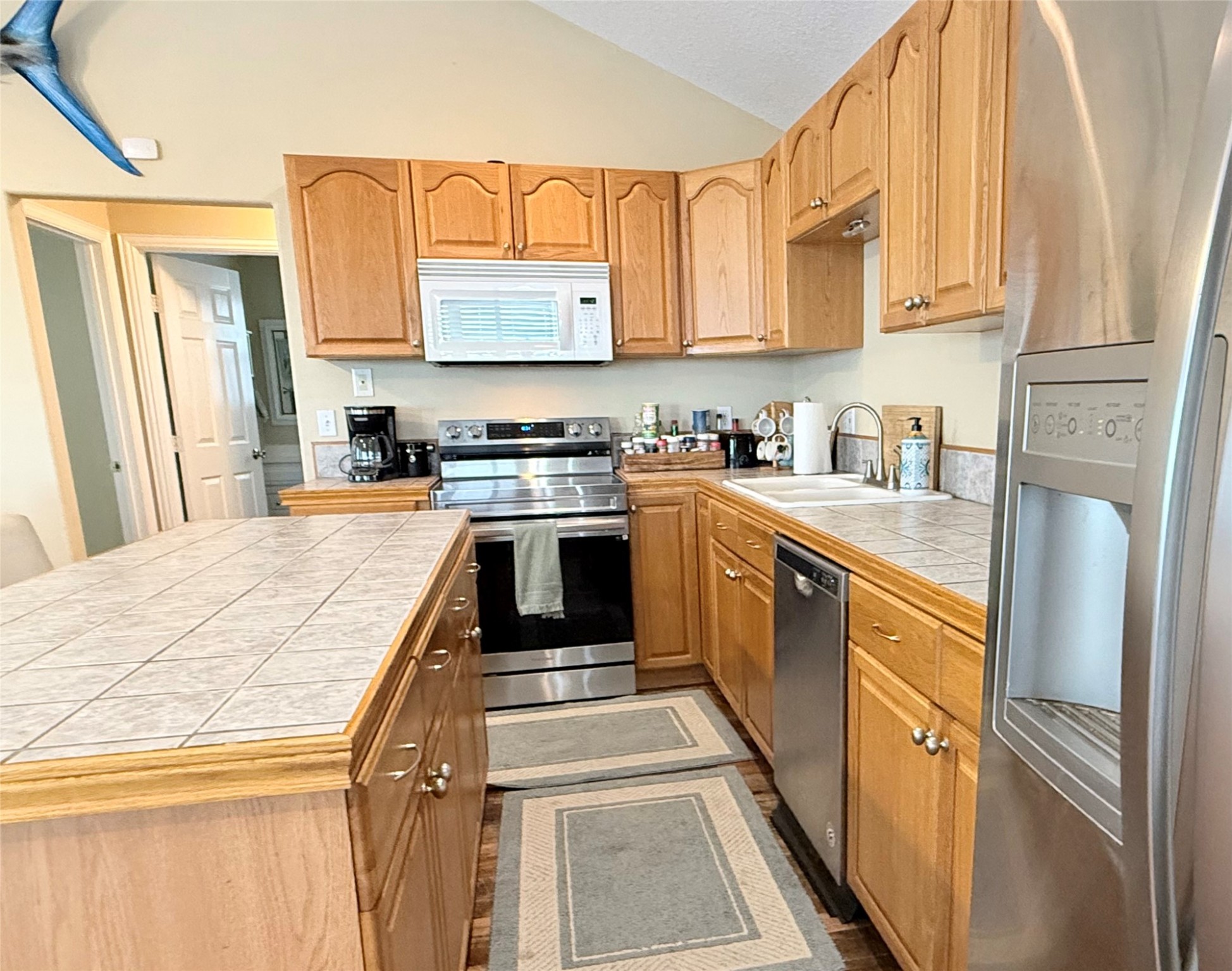 163 County Road 299 Sargent, TX 77414 - Photo 22 of 38 a kitchen with stainless steel appliances granite countertop a refrigerator a stove top oven a sink and dishwasher with wooden floor
