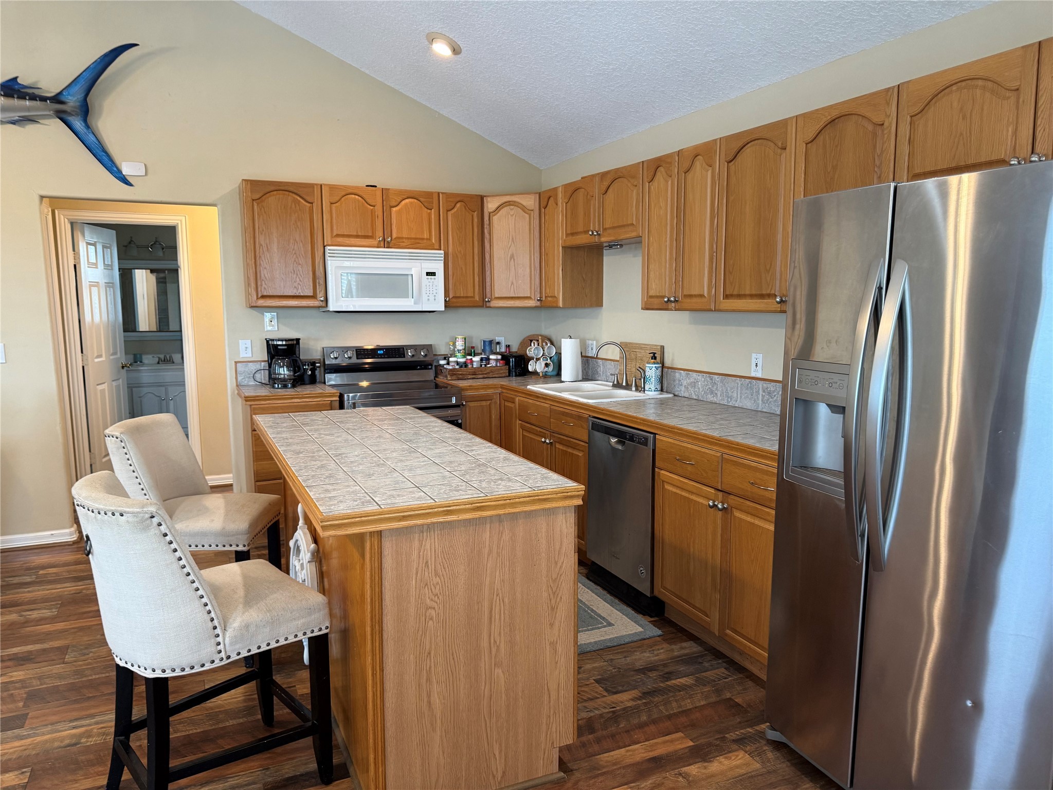 163 County Road 299 Sargent, TX 77414 - Photo 23 of 38 a kitchen with a refrigerator a stove a sink dishwasher with a dining table and chair with wooden floor