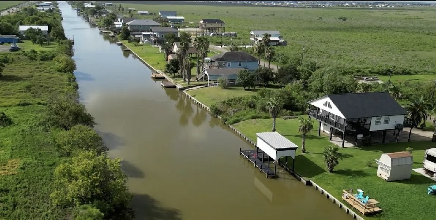 163 County Road 299 Sargent, TX 77414 - Photo 3 of 38 an aerial view of a house with outdoor space swimming pool and lake view