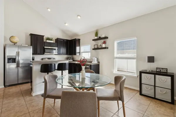 a kitchen with granite countertop a stove microwave and refrigerator