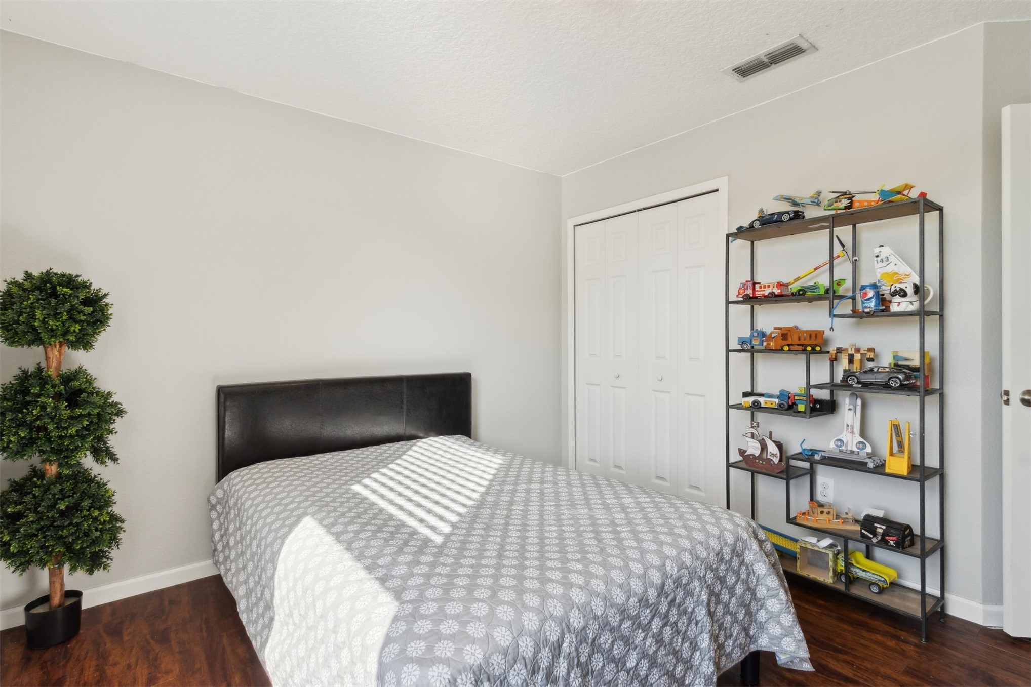 95029 Lavender Lane Fernandina Beach, FL 32034 - Photo 41 of 64 a bedroom with a bed a potted plant and a book shelf