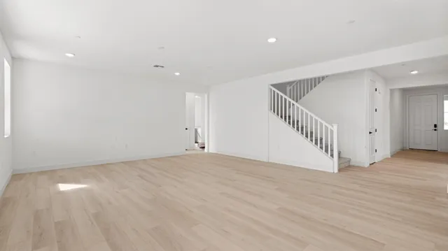 a view of an empty room with wooden floor and entryway