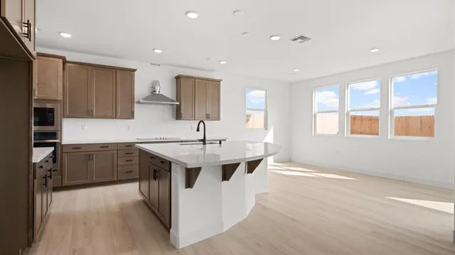 a kitchen with a sink dishwasher a stove and a refrigerator with wooden floor