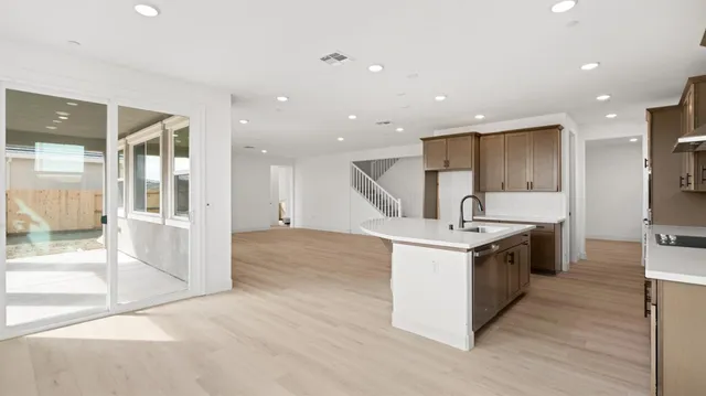 a kitchen with kitchen island granite countertop a sink stainless steel appliances and cabinets