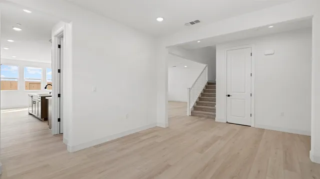 a view of a hallway with wooden floor and entryway