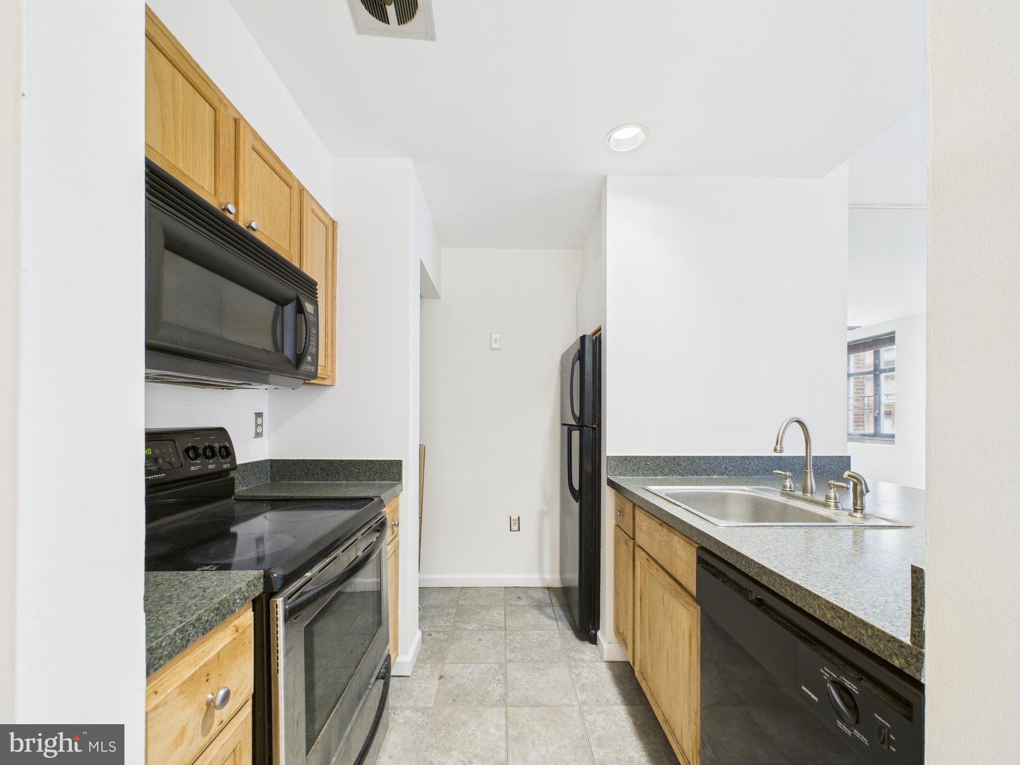 1601 Spring Garden Street, Unit 402 Philadelphia, PA 19130 - Photo 6 of 22 a kitchen with stainless steel appliances granite countertop a sink stove and refrigerator
