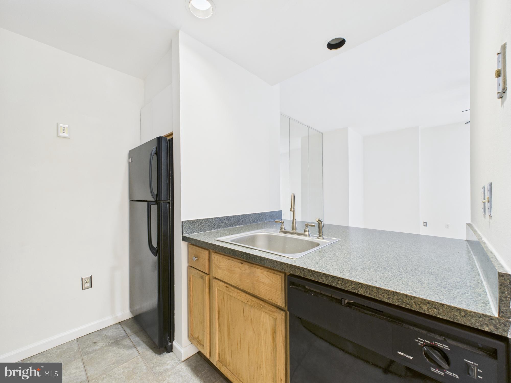 1601 Spring Garden Street, Unit 402 Philadelphia, PA 19130 - Photo 7 of 22 a kitchen with stainless steel appliances granite countertop a sink and a refrigerator
