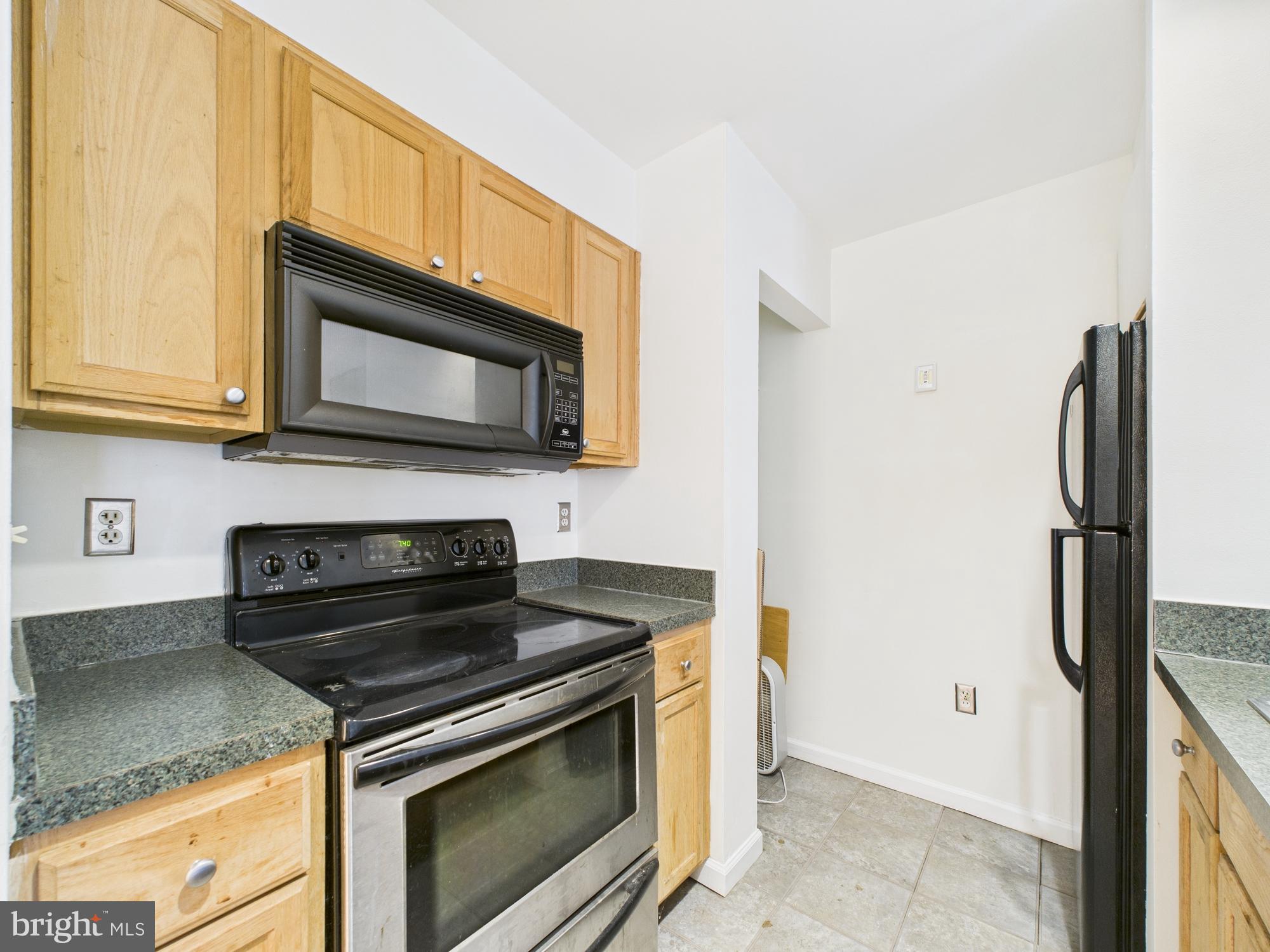 1601 Spring Garden Street, Unit 402 Philadelphia, PA 19130 - Photo 8 of 22 a kitchen with granite countertop cabinets stainless steel appliances and a counter space