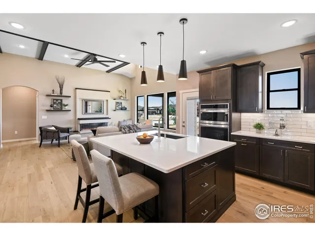 a kitchen with stainless steel appliances kitchen island granite countertop a table chairs and a refrigerator
