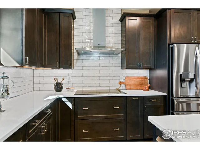 a kitchen with a sink a refrigerator and cabinets