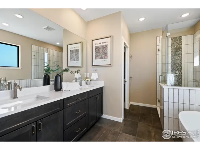 a bathroom with a double vanity sink a mirror and a shower