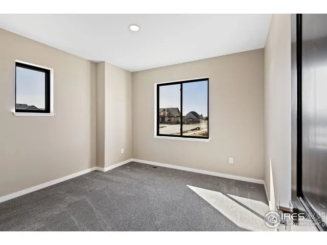 an empty room with windows and painting on the wall