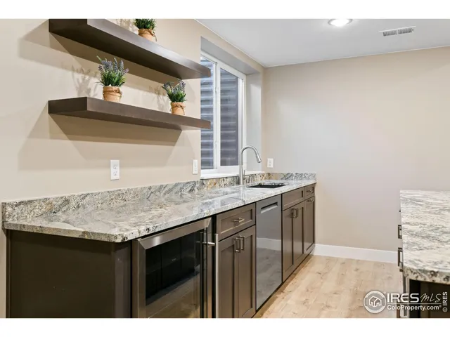 a kitchen with a sink a window and wooden floor