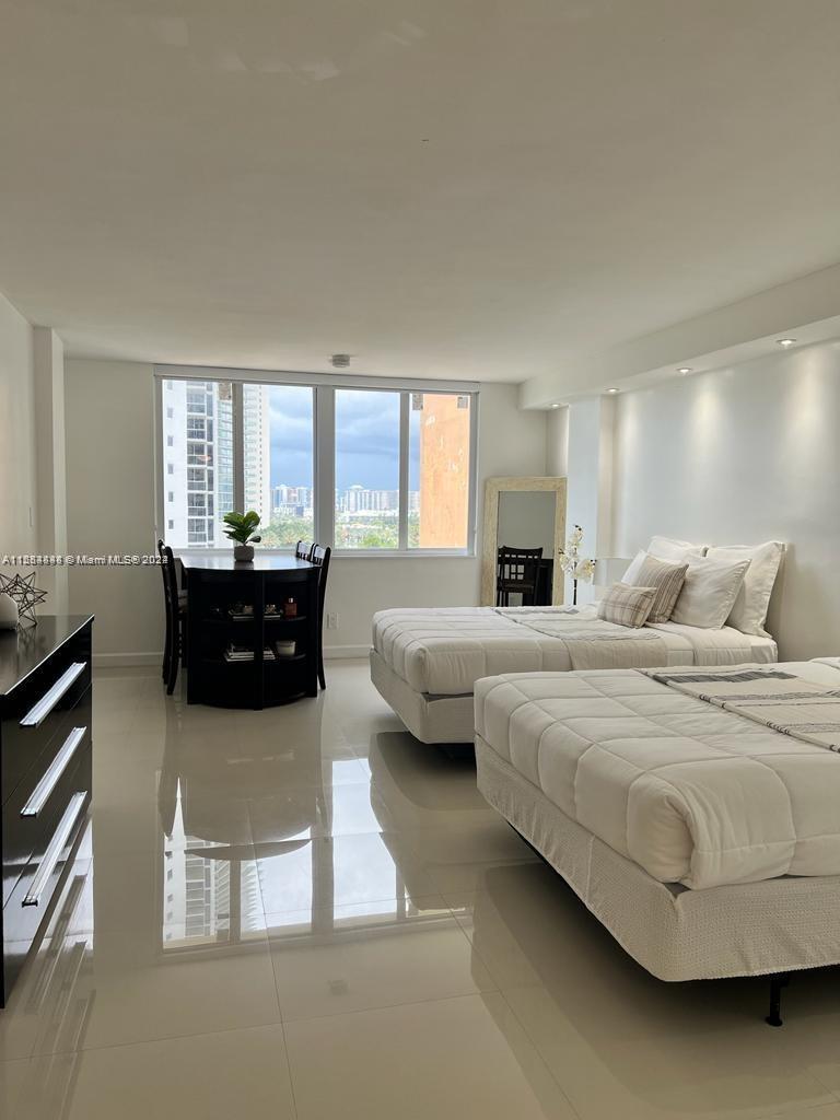 a spacious bedroom with a bed and glass windows