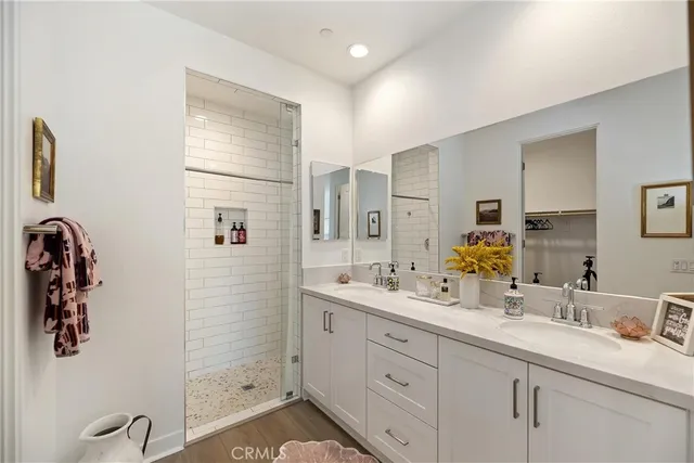 a spacious bathroom with double vanity a mirror and shower