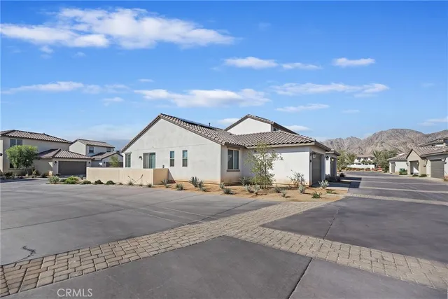a view of a house with a yard and pathway