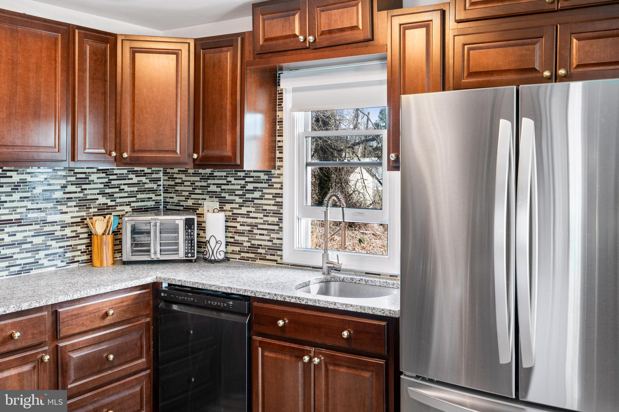 7745 Garrison Road Hyattsville, MD 20784 - Photo 11 of 43 a kitchen with stainless steel appliances granite countertop a refrigerator and a sink