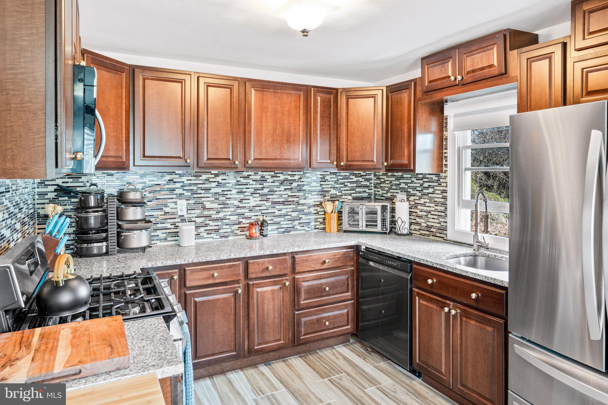 7745 Garrison Road Hyattsville, MD 20784 - Photo 9 of 43 a kitchen with stainless steel appliances granite countertop a sink stove and refrigerator