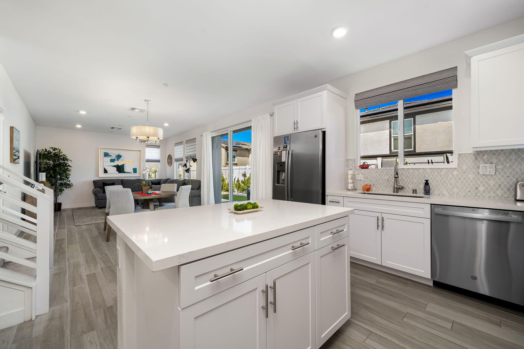 a kitchen with a sink a stove a refrigerator and white cabinets
