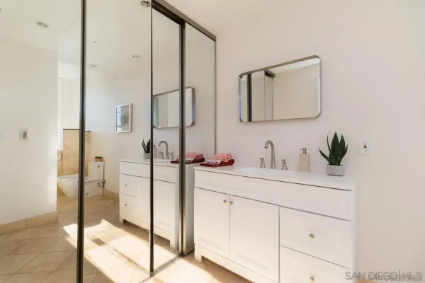 a bathroom with a double vanity sink mirror and shower
