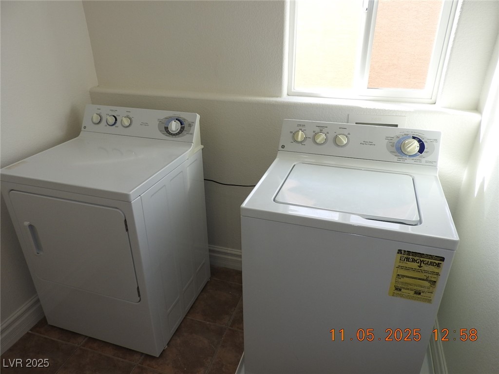 240 Rustic Club Way Las Vegas, NV 89148 - Photo 18 of 40 Washroom with washing machine and dryer and dark tile patterned floors