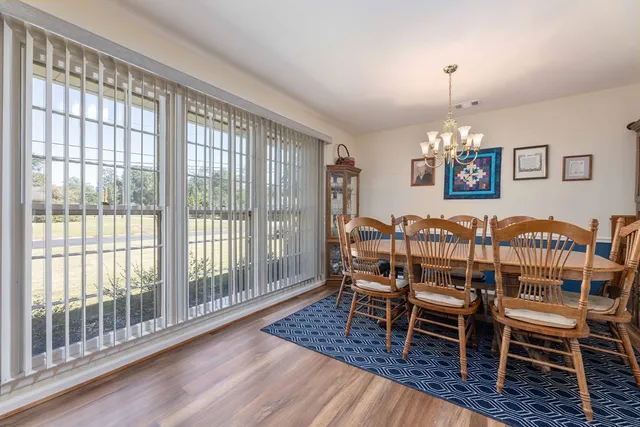 a dining room with furniture a chandelier and wooden floor