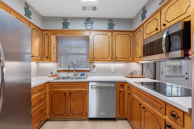 a kitchen with stainless steel appliances granite countertop a sink and a microwave