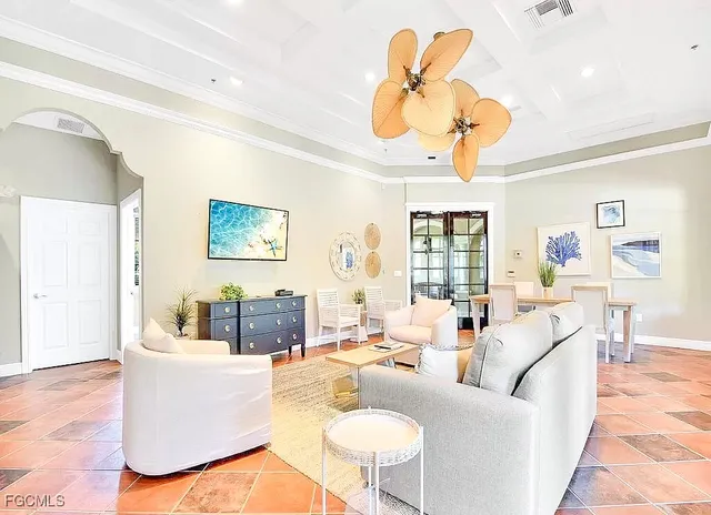 a living room with couches a dining table and a chandelier with wooden floor