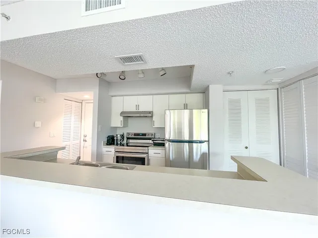 a kitchen with stainless steel appliances a stove a refrigerator and a sink